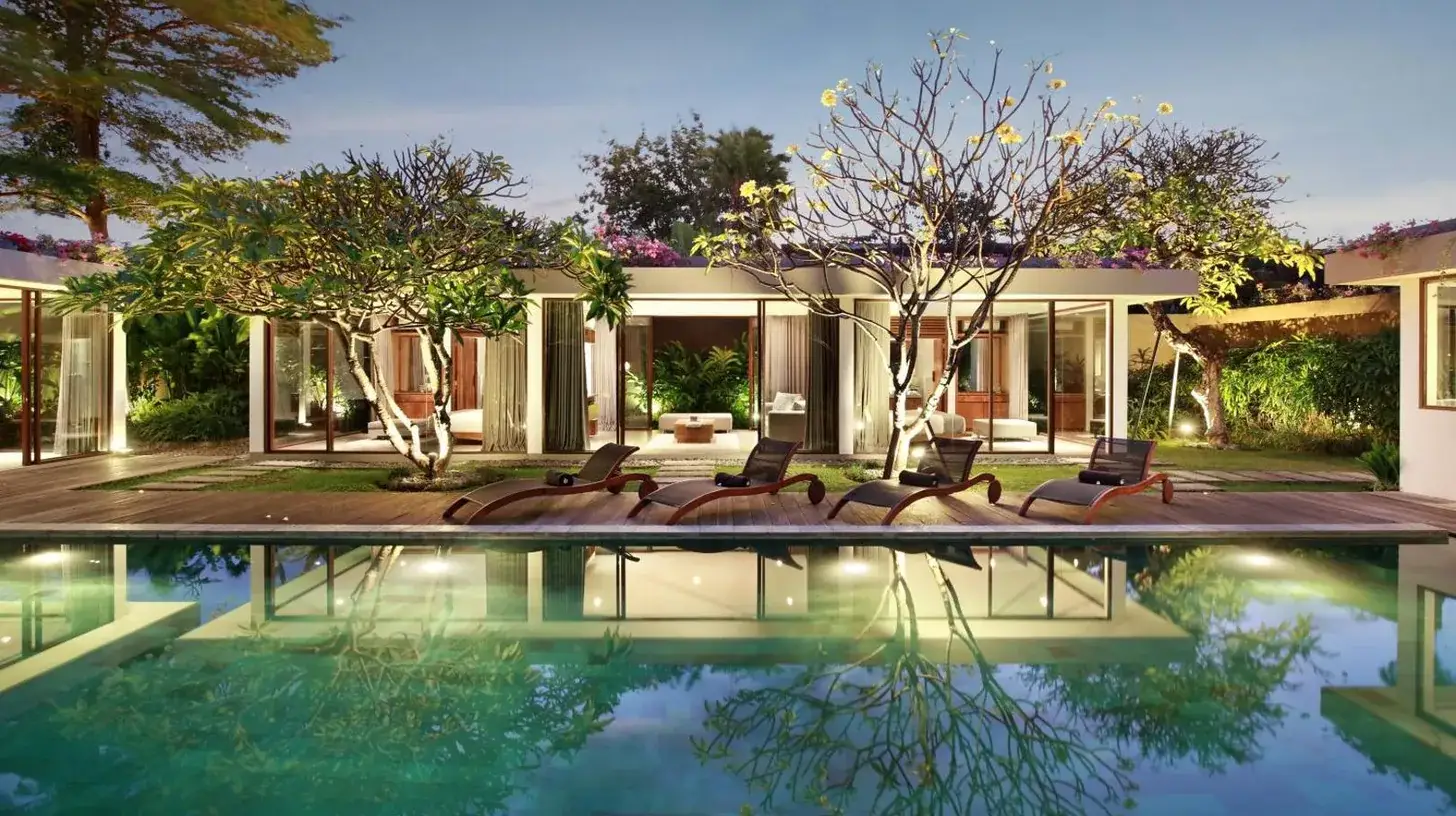 a house with a pool with chairs in front of it at Ziva a Boutique Villa in Seminyak